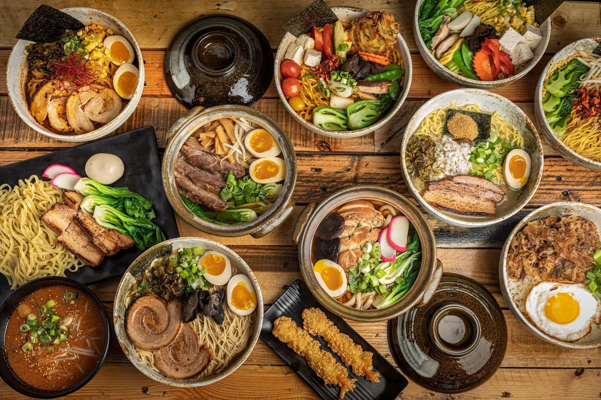 A spread of ramen bowls, donburi, dumplings and sides at Doragon Eatery