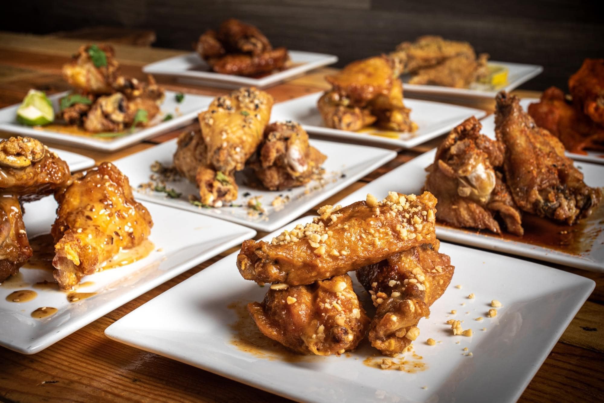 Plates of glazed wings in multiple sauces