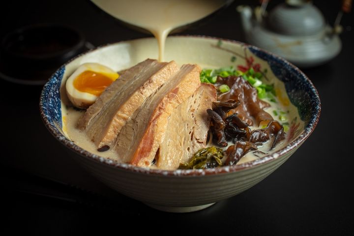 Steaming bowl of tonkotsu ramen with chashu pork, soft egg and nori